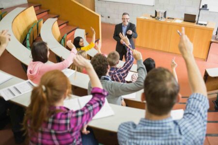 Students raising hands with lecturer picture for Higher education